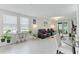 Modern living room with leather reclining chairs, stylish decor, and lots of natural light at 39024 Harlow Rose Dr, Zephyrhills, FL 33540