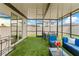 A covered patio featuring ample natural light, an artificial grass floor, and outdoor seating at 39024 Harlow Rose Dr, Zephyrhills, FL 33540