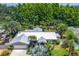 Stunning aerial view of a modern home featuring a metal roof, mature landscaping, and a lush, green wooded backdrop at 4096 38Th S St, St Petersburg, FL 33711