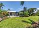Lush backyard with a well-maintained lawn, shaded by palm trees and featuring a charming patio seating area at 4096 38Th S St, St Petersburg, FL 33711