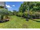 A spacious, well-manicured backyard featuring a lush lawn, vibrant landscaping, and privacy with mature hedges and trees at 4096 38Th S St, St Petersburg, FL 33711