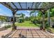 Serene backyard with wooden pergola, lush landscaping, and an umbrella-shaded patio for lounging at 4096 38Th S St, St Petersburg, FL 33711
