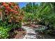 Stone walkway through a lush garden with beautiful plants and trees, creating a serene outdoor space at 4096 38Th S St, St Petersburg, FL 33711