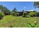 Lush backyard with a well-maintained lawn, shaded by palm trees and featuring a cozy pergola at 4096 38Th S St, St Petersburg, FL 33711
