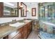 Bathroom featuring double sinks, stylish tile accents, and a glass-enclosed shower at 4096 38Th S St, St Petersburg, FL 33711