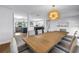 Open-concept dining room showcasing hardwood floors, a modern chandelier, and an inviting connection to the kitchen and living room at 4096 38Th S St, St Petersburg, FL 33711