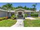 Inviting front entrance showcasing lush landscaping, a modern blue front door, and updated exterior lighting at 4096 38Th S St, St Petersburg, FL 33711