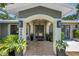 Elegant home entrance with a blue door framed by columns, potted plants, and travertine-tiled walkway at 4096 38Th S St, St Petersburg, FL 33711