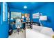 A vibrant blue office, with comfortable white sofa, with a well-lit desk area, and ample wall decor at 4096 38Th S St, St Petersburg, FL 33711