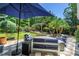 Outdoor patio with stylish seating under a shade umbrella, surrounded by lush landscaping at 4096 38Th S St, St Petersburg, FL 33711