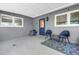 Covered patio with blue door and matching chairs and colorful rug at 4096 38Th S St, St Petersburg, FL 33711