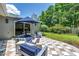 Outdoor patio with stylish seating under a shade umbrella and surrounded by lush green landscaping at 4096 38Th S St, St Petersburg, FL 33711