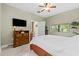 Bright bedroom with a TV, ceiling fan, and view from the window at 4103 Via Piedra Cir # 10-101, Sarasota, FL 34233