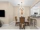 Cozy dining area with a glass-top table, stylish chairs, and an elegant chandelier at 4103 Via Piedra Cir # 10-101, Sarasota, FL 34233