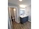 Bathroom features a modern vanity with framed mirror and updated lighting, plus a toilet in the adjoining room at 4470 Mainlands W Blvd, Pinellas Park, FL 33782