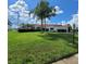 Well-maintained clubhouse with lush green lawn, a flag pole, and a red tile roof at 4470 Mainlands W Blvd, Pinellas Park, FL 33782