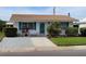 Charming single-story home with well-manicured lawn, tidy landscaping and blue shutters at 4470 Mainlands W Blvd, Pinellas Park, FL 33782