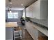 Kitchen features bright white cabinets and an island with white countertop, and stainless steel appliances at 4470 Mainlands W Blvd, Pinellas Park, FL 33782