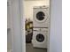 Modern laundry area with a stacked washer and dryer, and a hot water heater next to shelves at 4470 Mainlands W Blvd, Pinellas Park, FL 33782
