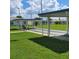 Shuffleboard courts with covered seating areas, set in a lush green lawn, showcasing a community activity at 4470 Mainlands W Blvd, Pinellas Park, FL 33782
