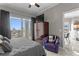 This cozy bedroom offers a balcony, TV atop a wooden cabinet and an armchair for comfortable relaxation at 449 S 12Th St # 1004, Tampa, FL 33602