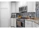Well-equipped kitchen with stainless steel oven, microwave, range hood, and granite countertops at 449 S 12Th St # 1004, Tampa, FL 33602