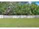 A sprawling, well-maintained lawn enclosed by a white fence and lush green trees at 4918 Wild Senna Blvd, Tampa, FL 33619