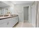 Bathroom featuring double sinks, granite counters, large mirror and shower with tile surround at 4918 Wild Senna Blvd, Tampa, FL 33619