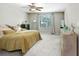 Comfortable bedroom featuring plush carpet, ceiling fan, neutral walls, large window and dresser storage at 4918 Wild Senna Blvd, Tampa, FL 33619
