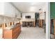 Bright kitchen in need of renovation with white cabinets, tile floors, stainless microwave and open concept layout at 4928 Petunia Ct, New Port Richey, FL 34652
