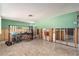 Spacious living room in need of renovation featuring tile floors, and a view into the kitchen and bathroom at 4928 Petunia Ct, New Port Richey, FL 34652