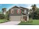 Charming two-story home featuring a neutral color scheme, stone accents, a two-car garage, and a neatly landscaped front yard at 5212 Salt Marsh Rd, Wimauma, FL 33598