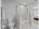 Well-lit bathroom features a step-in shower with glass enclosure and neutral tile surround at 5813 Grand Sonata Ave, Lutz, FL 33558