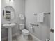 Comfortable bathroom featuring a sink, toilet, grab bars, and ample storage space at 5813 Grand Sonata Ave, Lutz, FL 33558