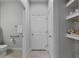 Bathroom hallway includes sink with towel, toilet, and shelves for storage at 5813 Grand Sonata Ave, Lutz, FL 33558