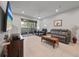 Bright living room with tile flooring, ceiling fan, sliding glass doors, and contemporary furnishings at 5813 Grand Sonata Ave, Lutz, FL 33558
