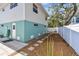 Side yard with sidewalk, clean modern paint job and partial fence at 616 2Nd St, Indian Rocks Beach, FL 33785