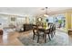 Open-concept dining room with wood table and chairs, wood floors, and access to both living room and outdoor patio at 616 2Nd St, Indian Rocks Beach, FL 33785