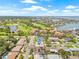 Scenic aerial view of the neighborhood with golf course, ponds, and a glimpse of water views in the distance at 6400 Mockingbird S Way, St Petersburg, FL 33707