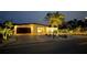 Beautiful single-story home with a meticulously landscaped front yard and paver driveway, illuminated by landscape lighting at 6400 Mockingbird S Way, St Petersburg, FL 33707