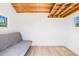 Bright and airy interior featuring wooden ceiling, wood-look flooring, white-washed walls and a grey futon, creating a serene space at 6400 Mockingbird S Way, St Petersburg, FL 33707