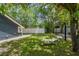 Spacious backyard featuring a well-maintained lawn, shade trees, stone benches, and a perimeter fence at 6401 N Central Ave, Tampa, FL 33604