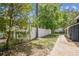 Property with a brick walkway, verdant backyard featuring a privacy fence, and mature shade trees at 6401 N Central Ave, Tampa, FL 33604