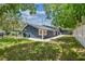 Well-maintained backyard features lush lawn, blue siding, mature trees, and white fencing at 6401 N Central Ave, Tampa, FL 33604