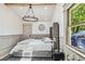 Bedroom boasting natural light, a comfortable bed, wood floors, a modern light fixture, and neutral color tones at 6401 N Central Ave, Tampa, FL 33604