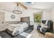 Spacious bedroom features a comfortable bed, chandelier, skylight, and a cozy sitting area by the window at 6401 N Central Ave, Tampa, FL 33604