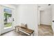 Bright entryway with wood bench seating and views of the exterior and the home's updated herringbone flooring at 6401 N Central Ave, Tampa, FL 33604