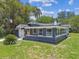 Charming home with a dark exterior, a welcoming front porch, well-manicured lawn, and ample curb appeal at 6401 N Central Ave, Tampa, FL 33604