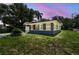 Charming single-story home with a well-manicured lawn and attached garage at dusk at 6401 N Central Ave, Tampa, FL 33604