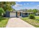 Charming single-story home with a well-manicured lawn and attached garage at 6401 N Central Ave, Tampa, FL 33604
